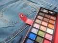 Pocket travel makeup palette on jeans Royalty Free Stock Photo