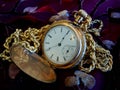 Vintage gold pocket watch with chain on fabric background