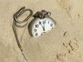 Pocket watch buried in sand. Royalty Free Stock Photo