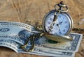 Pocket watch with dollars on wooden trunk Royalty Free Stock Photo