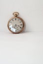 Pocket watch in gold on white paper and supported on the wall Royalty Free Stock Photo