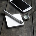 Pocket watch, mobile phone and notebook on table