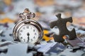 Pocket watch on a pile of jigsaw puzzle pieces Royalty Free Stock Photo