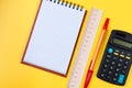 Pocketbook and calculator on yellow background.