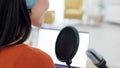 Podcast, broadcast and live streaming with a woman using a microphone while recording a talkshow for radio. Laptop