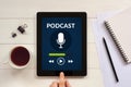 Podcast concept on tablet screen with office objects