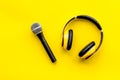 Podcast record with microphone and headphones on yellow background top view