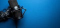 Podcast studio setup microphone, headphones, blue background Royalty Free Stock Photo