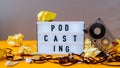 Podcasting lettering and audio cassette tape, headphones, crumpled paper in minimalistic isometric style. Trendy colors. Grey and