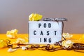 Podcasting lettering and audio cassette tape, headphones, crumpled paper in minimalistic isometric style. Trendy colors. Grey and