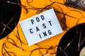 Podcasting lettering and vinyl record album audio cassette tape on yellow background. Millenial. Blogger, podcaster. Retro style