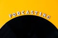 Podcasting lettering and vinyl record album in minimalistic style on yellow background. Millenial. Blogger, podcaster. Retro style