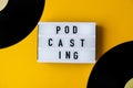 Podcasting lettering and vinyl record album in minimalistic style on yellow background. Millenial. Blogger, podcaster. Retro style