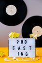 Podcasting lettering and vinyl record albums, headphones, crumpled paper in minimalistic isometric style. Trendy colors. Grey and