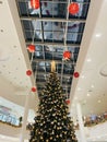 Podgorica, Montenegro - 25 december 2022: Decorated with balls and garlands, a tall Christmas tree stands in a shopping