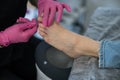 Podiatrist makes a pedicure to a client. The master conducts hygiene of the toes with a metal stick. Royalty Free Stock Photo