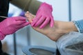 Podiatrist makes a pedicure to a client. The master conducts hygiene of the toes with a metal stick. Royalty Free Stock Photo