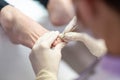 Podiatrist removing cuticle from a toenail