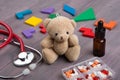 Podiatrist workplace - toy bear, stethoscope and medicines on the wooden desk - children health care concept