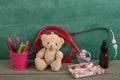 Podiatrist workplace - toy bear, stethoscope and medicines on the wooden desk - children health care concept