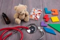 Podiatrist workplace - toy bear, stethoscope and medicines on the wooden desk - children health care concept