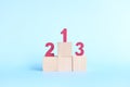 Podium, ranking and hierarchy concept. Wooden blocks with numbers 123 in blue background. Royalty Free Stock Photo