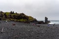 Poeople walking on Djupalonssandur black sand beach in Iceland Royalty Free Stock Photo