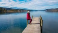 Poertschach - Woman sitting on the pier of the Woerthersee in Carinthia Royalty Free Stock Photo