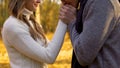 Poet kissing hands of his beloved woman, romantic atmosphere in autumn wood Royalty Free Stock Photo