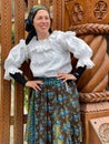 Poienile Izei, Maramures, May the 2nd 2021: Woman wearing traditional in front of wood gate