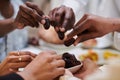 In a poignant close-up, the diverse hands of a Muslim family delicately grasp fresh dates, symbolizing the breaking of