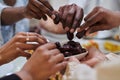 In a poignant close-up, the diverse hands of a Muslim family delicately grasp fresh dates, symbolizing the breaking of