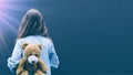 a girl looking at a gloomy wall with a teddy bear at her back trying to cope with her mental illness