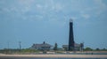 Point Bolivar Lighthouse on the shore in Texas against the blue cloudy sky