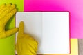 Point gloved finger to a blank magazine page. Bright pink and yellow background. hazard