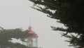 Old lighthouse fresnel lens glowing, foggy rainy weather. Illuminated beacon USA Royalty Free Stock Photo