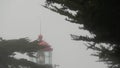 Old lighthouse fresnel lens glowing, foggy rainy weather. Illuminated beacon USA Royalty Free Stock Photo