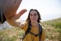 Point of view shot male hiker with backpack giving high five and smiling.