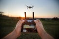 Point of view shot of man holding remote controller with his hands and taking aerial photo video. Quadcopter is flying Royalty Free Stock Photo