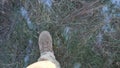 Point of view to female feet of ukrainian soldiery going in brown boots through dry grass at countryside. Legs of young