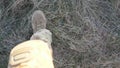 Point of view to female feet of ukrainian soldiery going in brown boots through dry grass at countryside. Legs of young