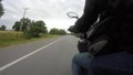 The point of view of a touring motorcycle rider on a rural road in thailand