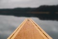 Point of view of a wooden canoe on the lake. Paddling in autumn or spring, no people