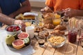 Point of view on the wooden table set for the breakfast. Table on the terrace under the sun. Fresh fruit and sweet food to start Royalty Free Stock Photo