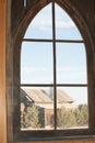 Pointed Arched Window with an old wooden building in view.