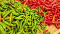 Pointed red and green peppers, in vivid contrast colours, displayed on food market.