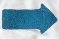 Pointer made of denim fabric with yellow stitching on white silk Royalty Free Stock Photo