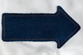 Pointer made of denim fabric with yellow stitching on white silk Royalty Free Stock Photo