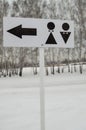 A pointer to a public toilet and the sign of a man and a woman. Hygiene in the Park, open, vertical frame