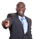 Pointing african businessman in a dark suit Royalty Free Stock Photo